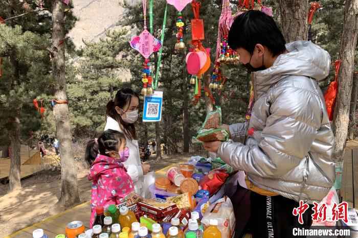 游客在景区商铺购买食品。 李佩珊 摄 贺兰山间春风起 游客理性踏青游
