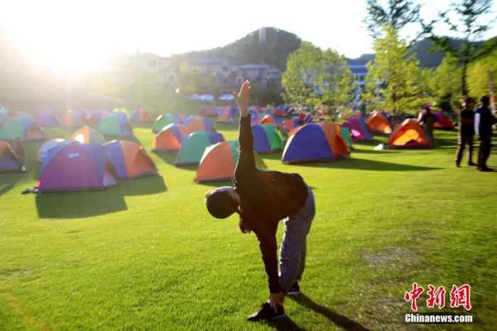 资料图:2019年7月7日,数千游客来到河南洛阳伏牛山清凉界海拔1700米的腹地安营扎寨,避暑纳凉。图为游客山中练瑜伽。中新社记者 王中举 摄 疫情期间的美食家们,体重上涨的你们可以这样减肥!